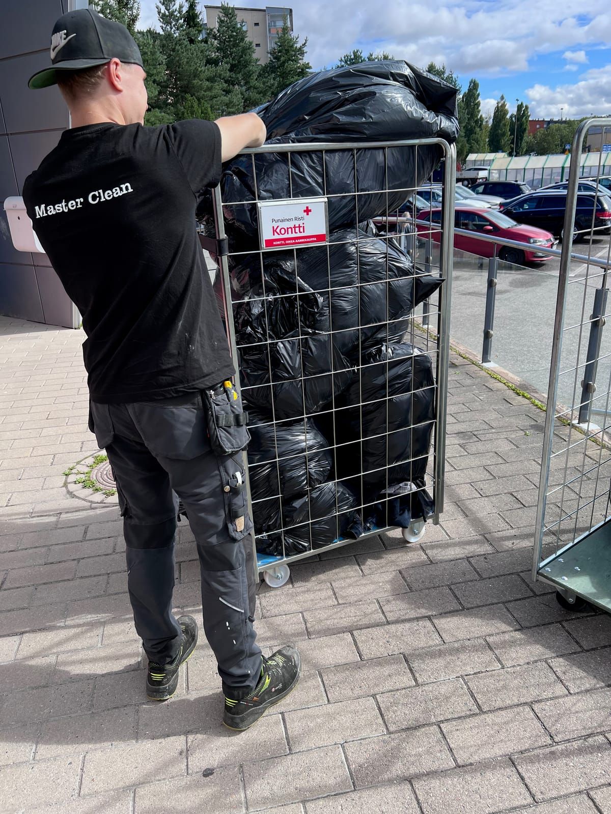 Master Teamin työntekijä vie vaatelahjoituksia Punaisen Ristin Konttiin